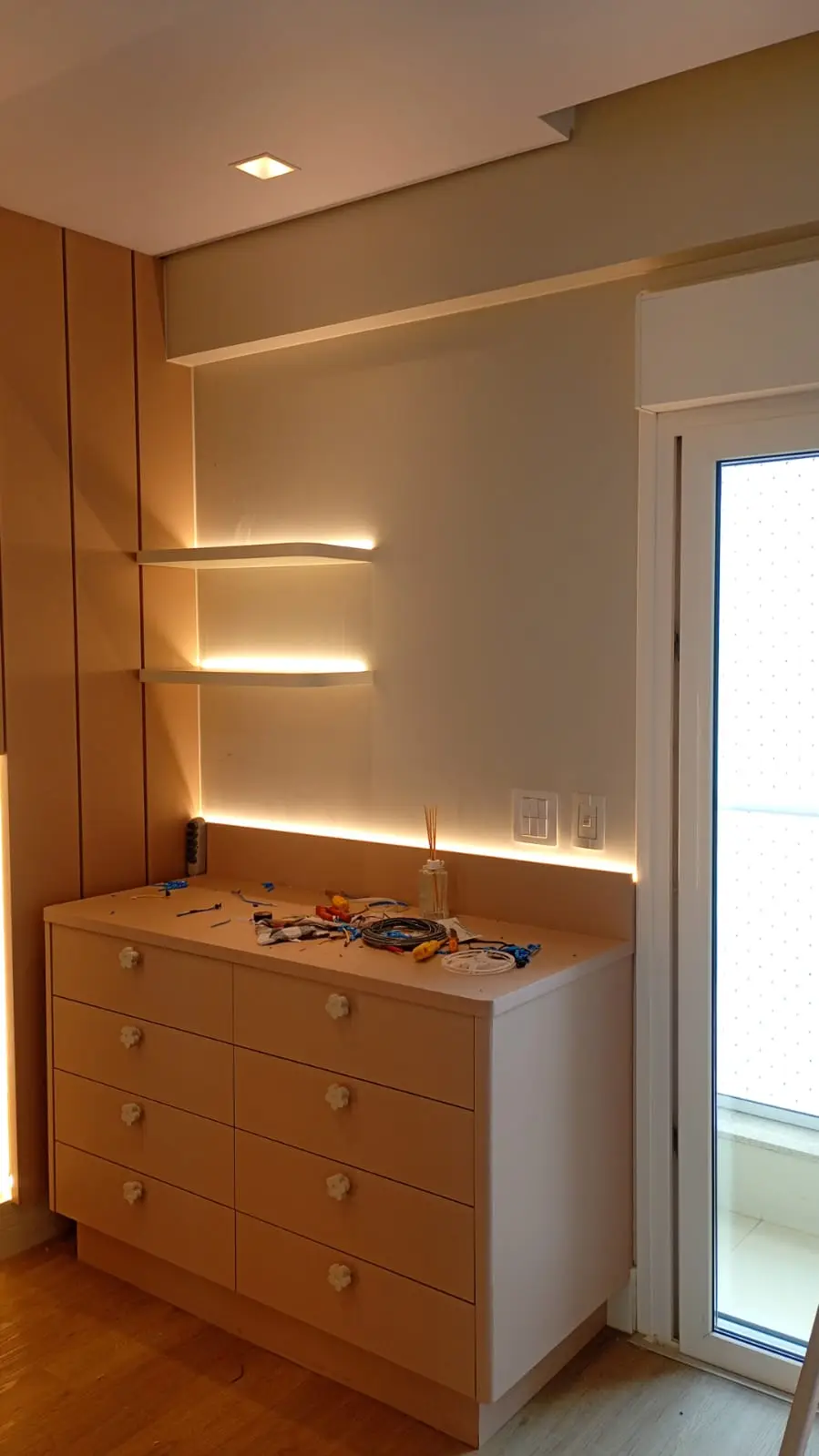 Armário com nichos iluminados por fitas de LED.