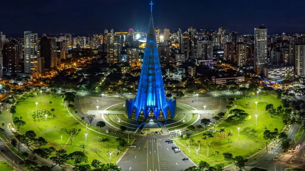 Catedral de Maringá iluminada à noite, com a cidade ao fundo.