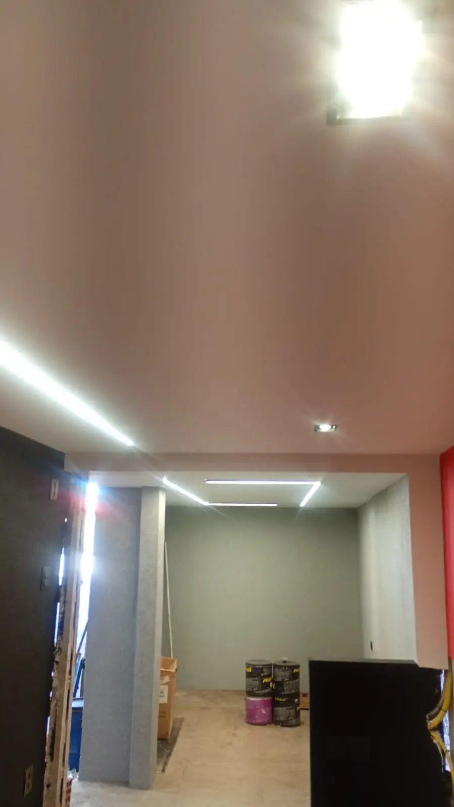 Corredor com iluminação linear em LED e spots no teto.