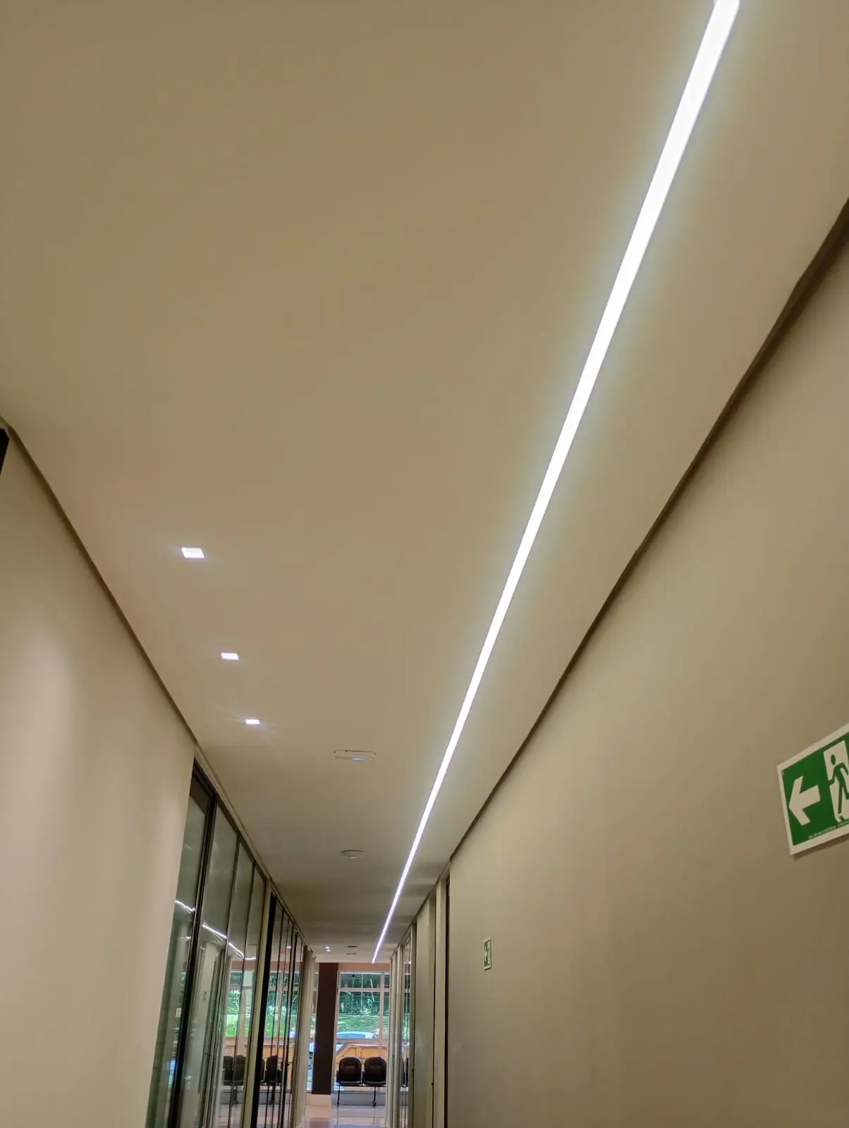 Corredor de área comum com linha de LED e spots instalados.