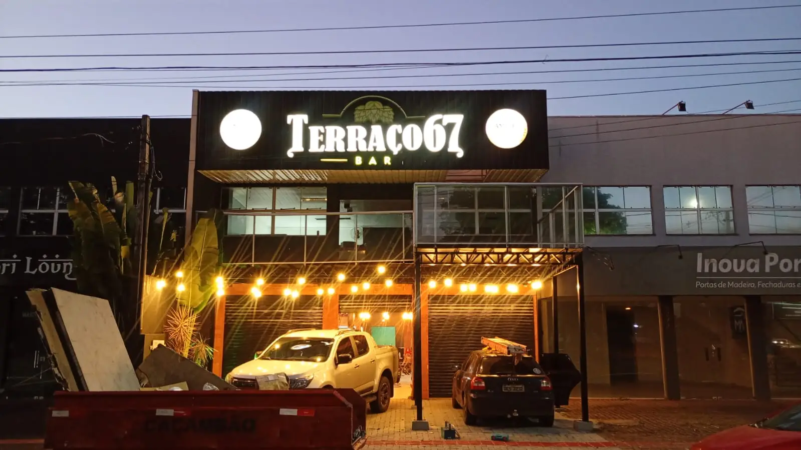 Fachada comercial iluminada durante a noite.