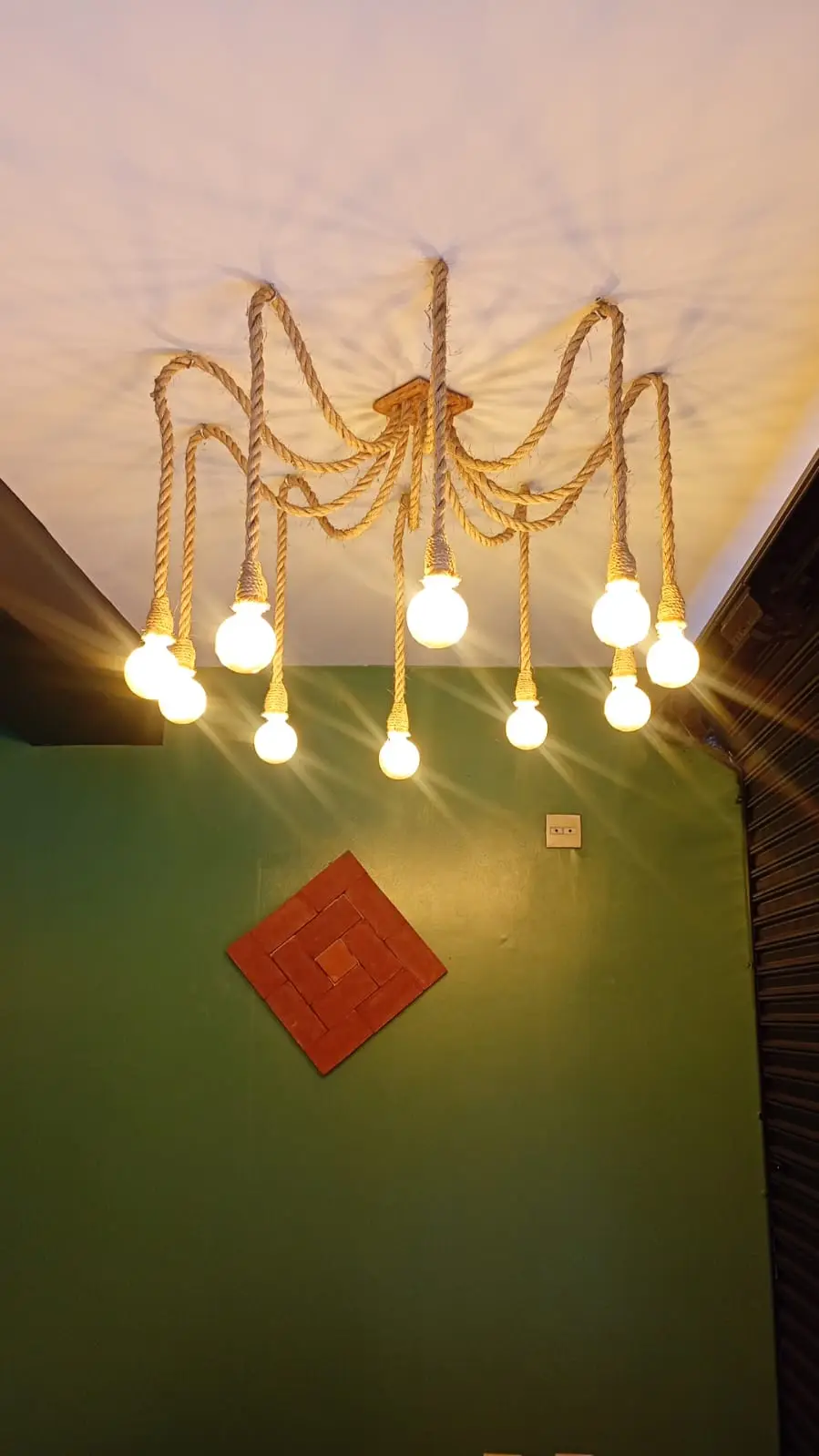 Lustre com lâmpadas aparentes em ambiente interno.