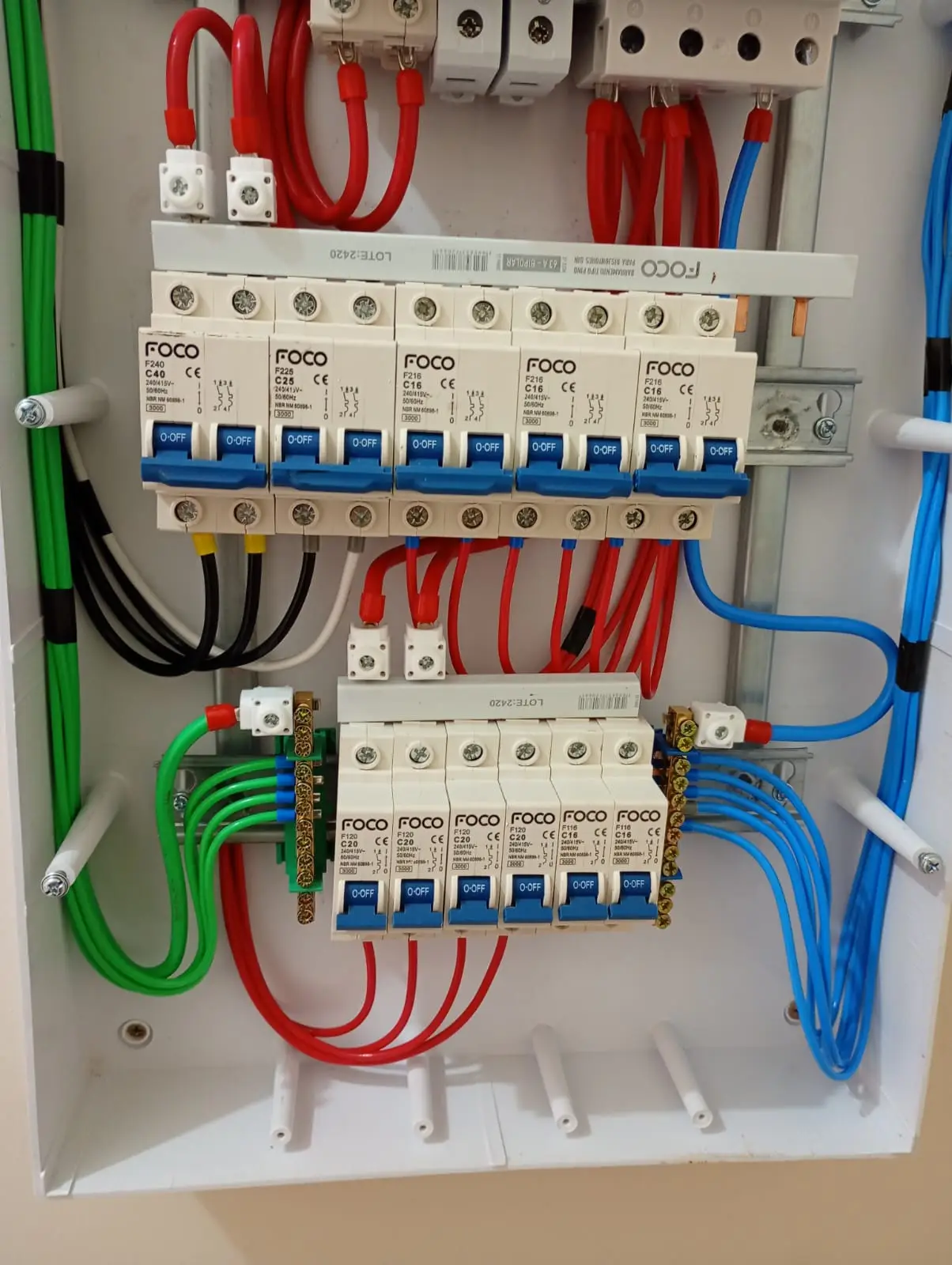 Detalhe de quadro elétrico com disjuntores e fiação interna.