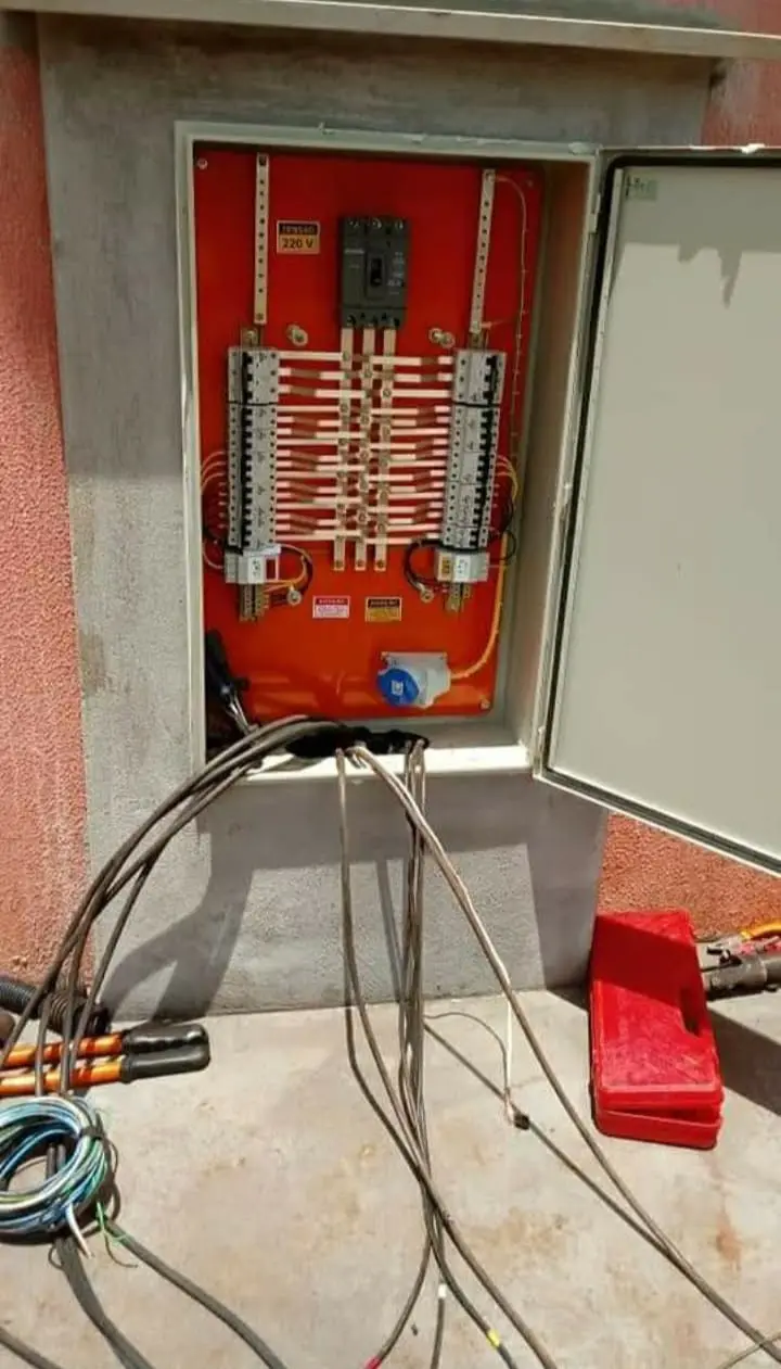 Quadro elétrico embutido em obra, com tampa aberta e cabeamento visível.