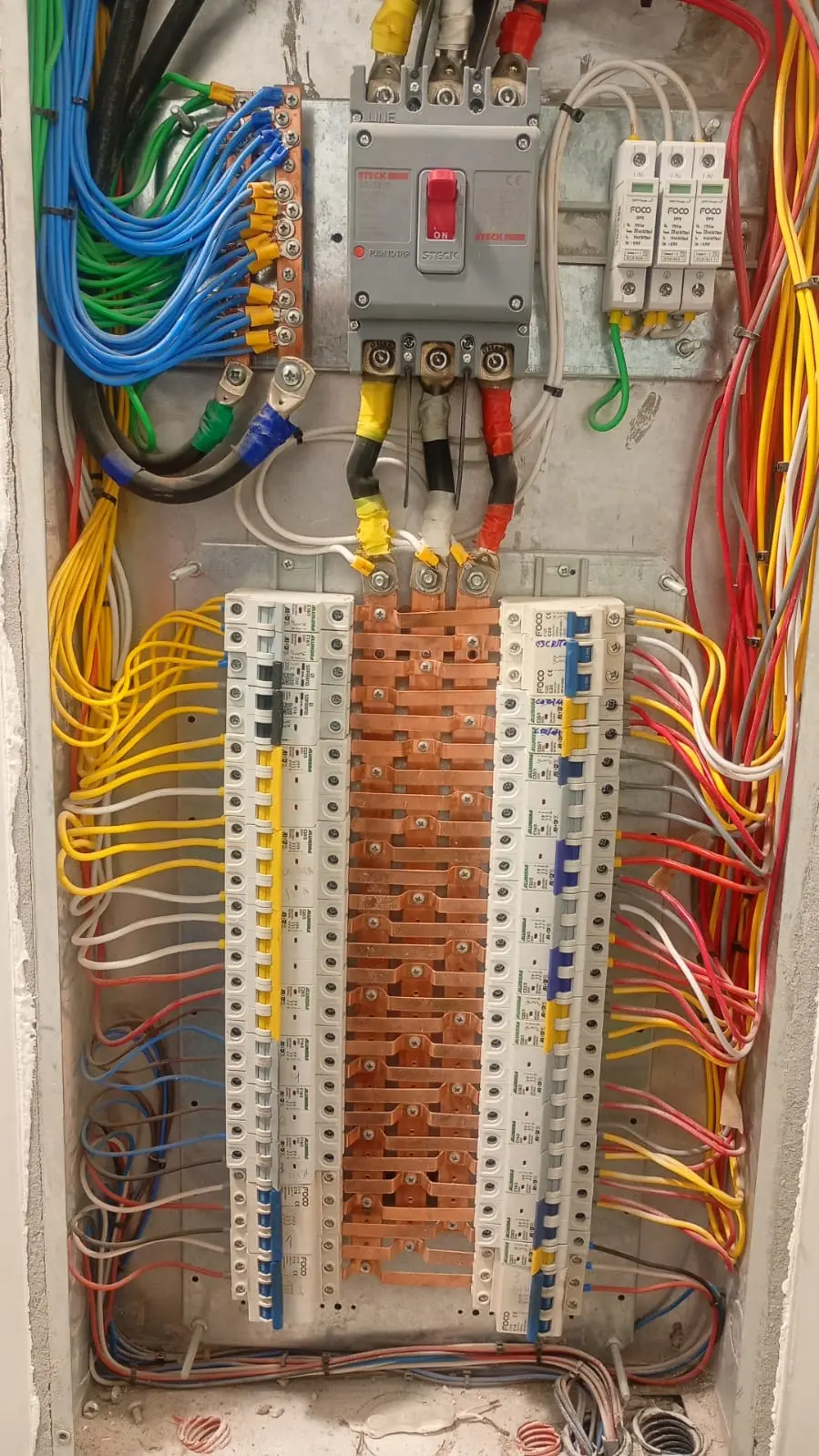 Quadro elétrico com fiação e disjuntores organizados.