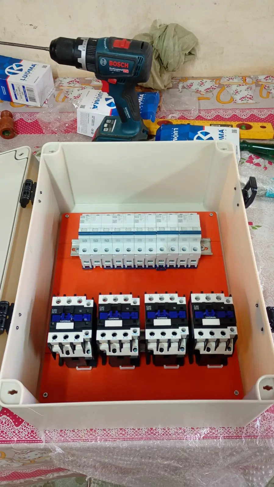 Quadro elétrico em montagem sobre bancada.