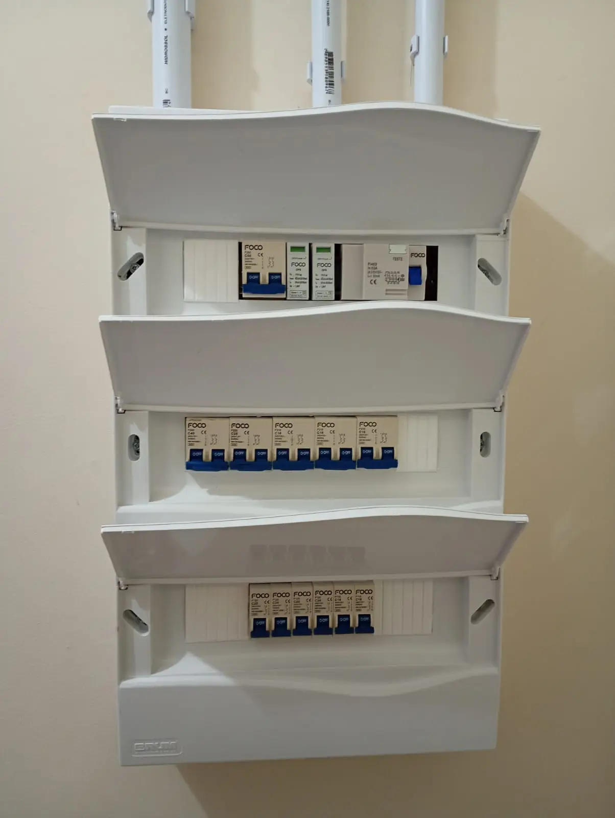 Conjunto de quadros elétricos com tampas abertas e disjuntores.
