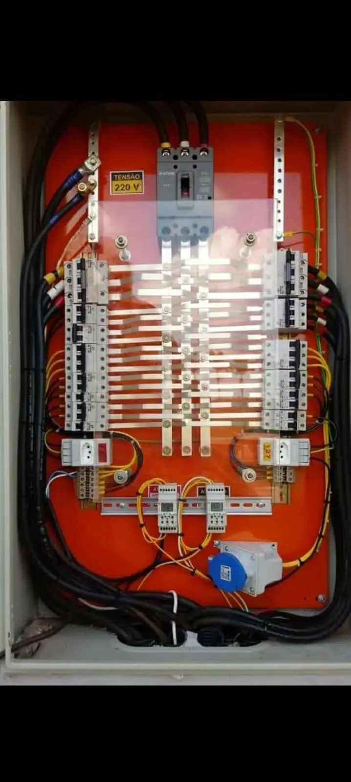 Painel elétrico vermelho com disjuntores e barramentos instalados.