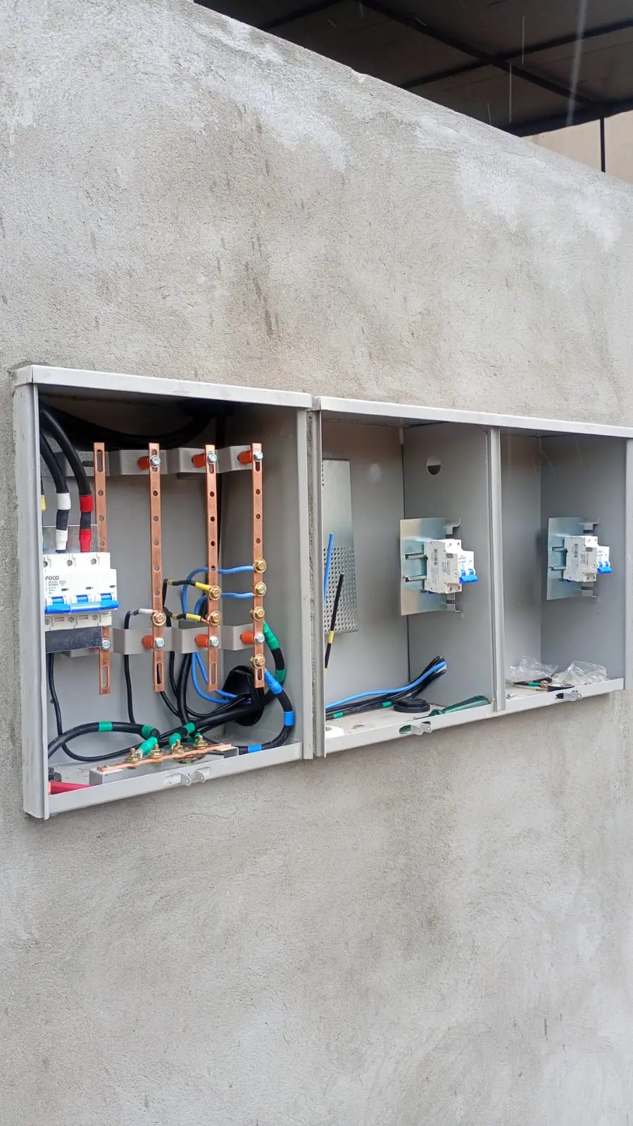 Sequência de quadros elétricos abertos instalados em parede.