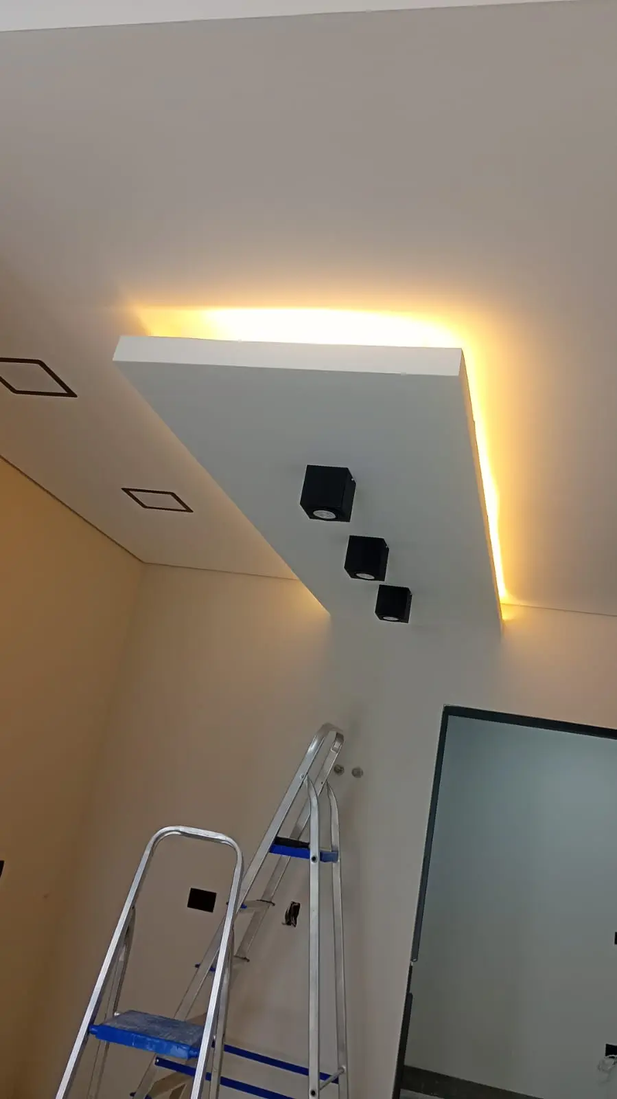 Ambiente interno com sanca de LED e spots embutidos.