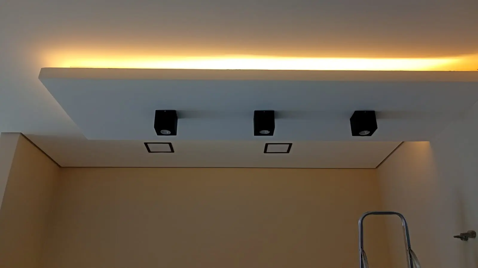 Teto com iluminação indireta em LED e spots direcionáveis.
