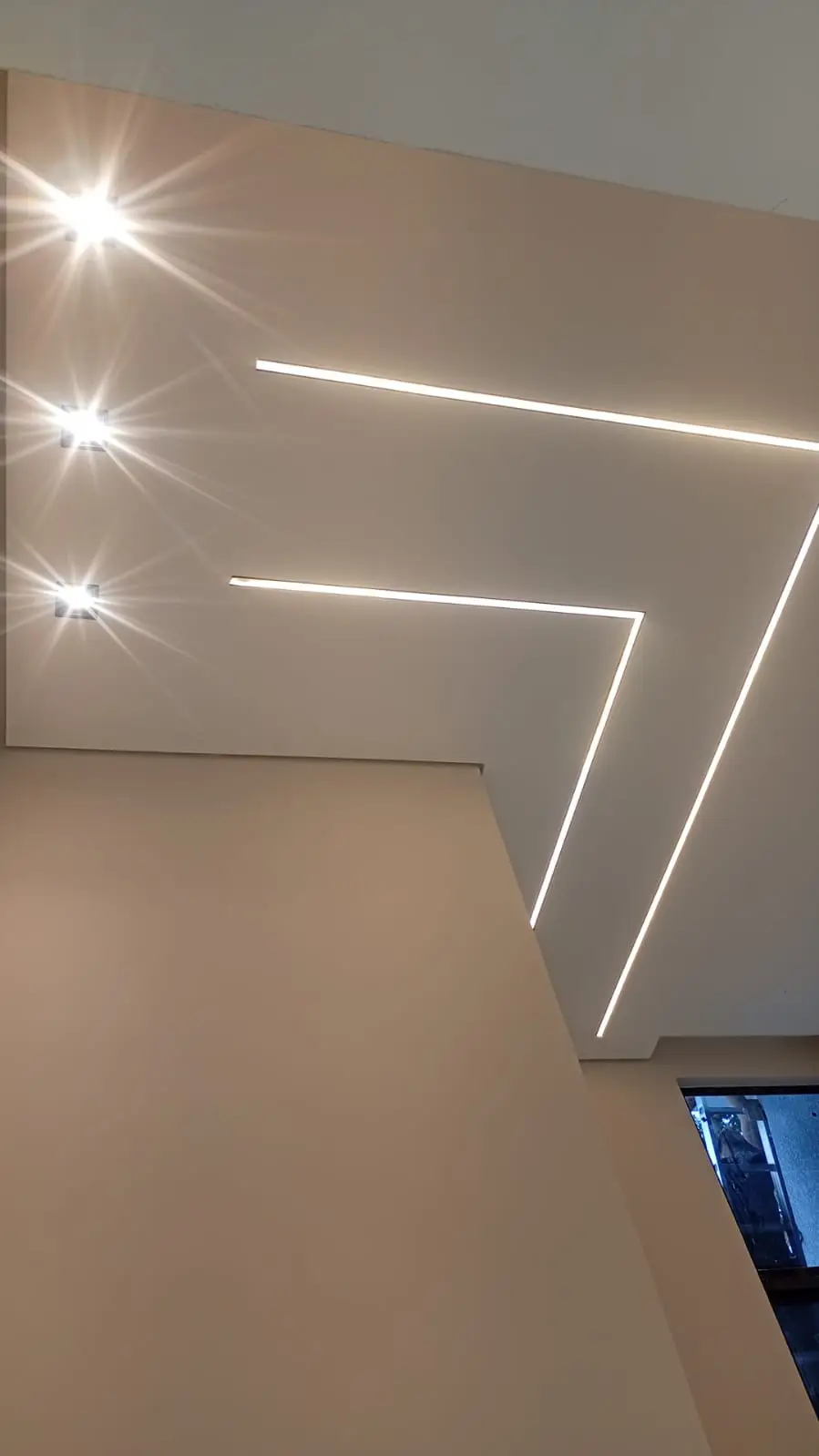 Teto com linhas geométricas de LED em ambiente interno.