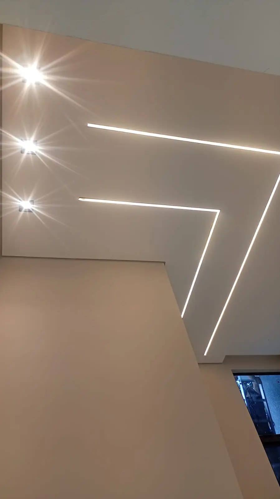 Teto com linhas geométricas de LED em ambiente interno.