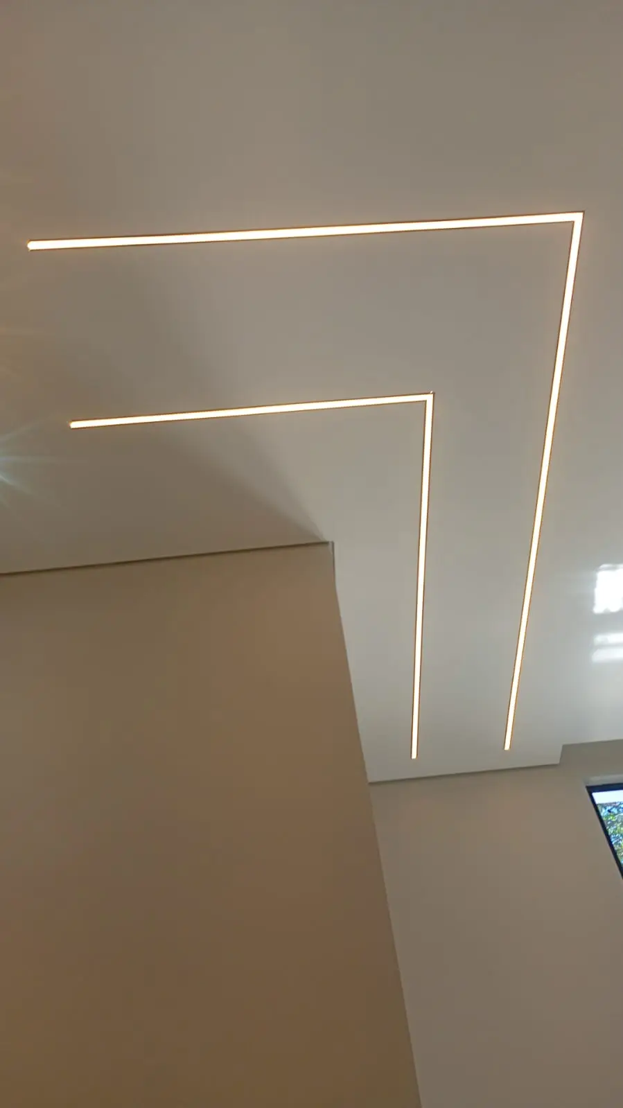 Teto com linhas de LED formando desenho geométrico.