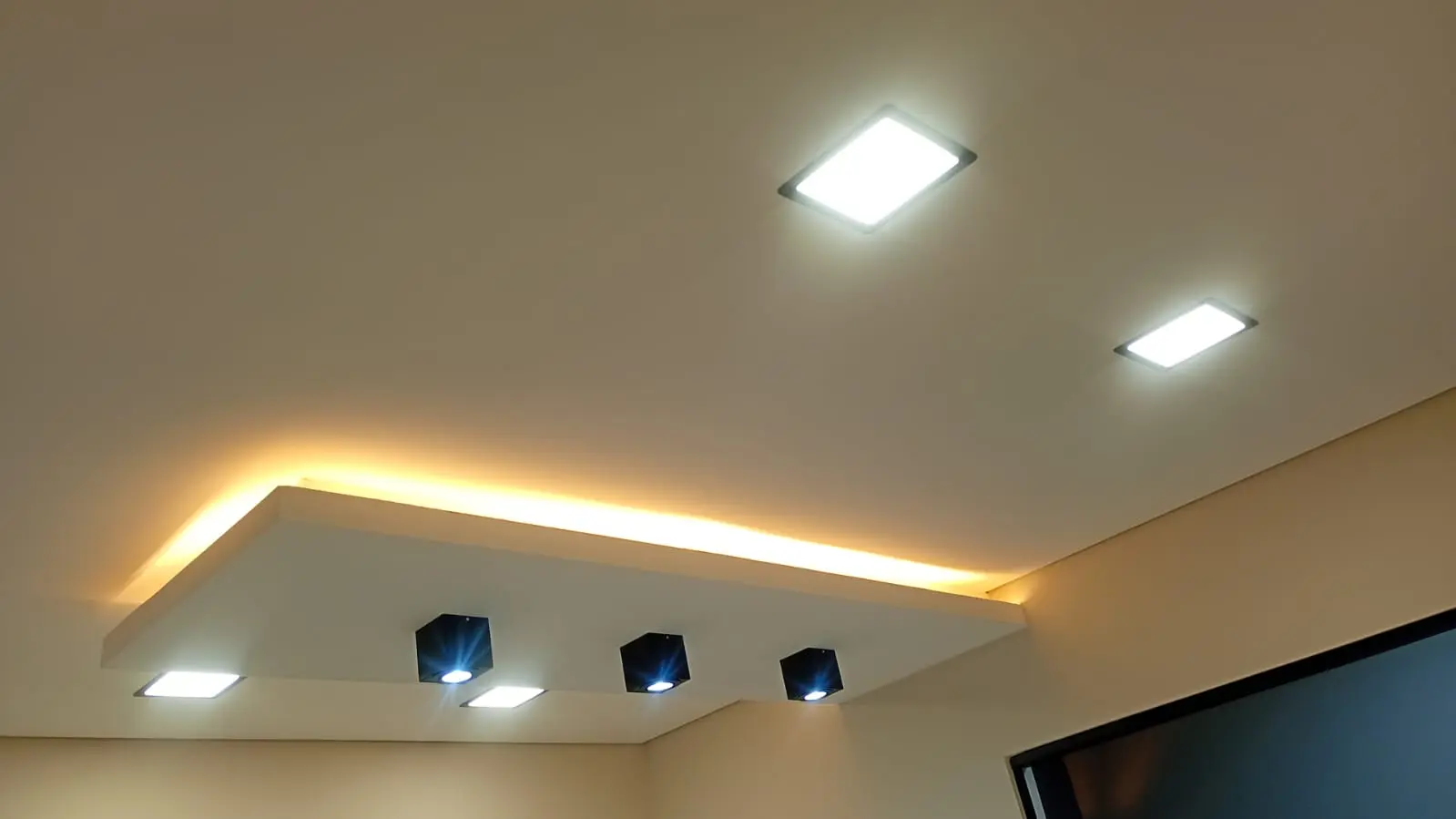 Teto com sanca iluminada e spots de LED embutidos.